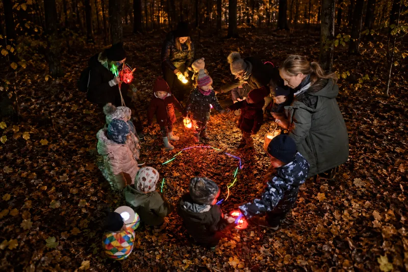Halloween s dětmi 2026: stezky odvahy a další akce děti s rodiči procházejí večerní stezku odvahy v lese